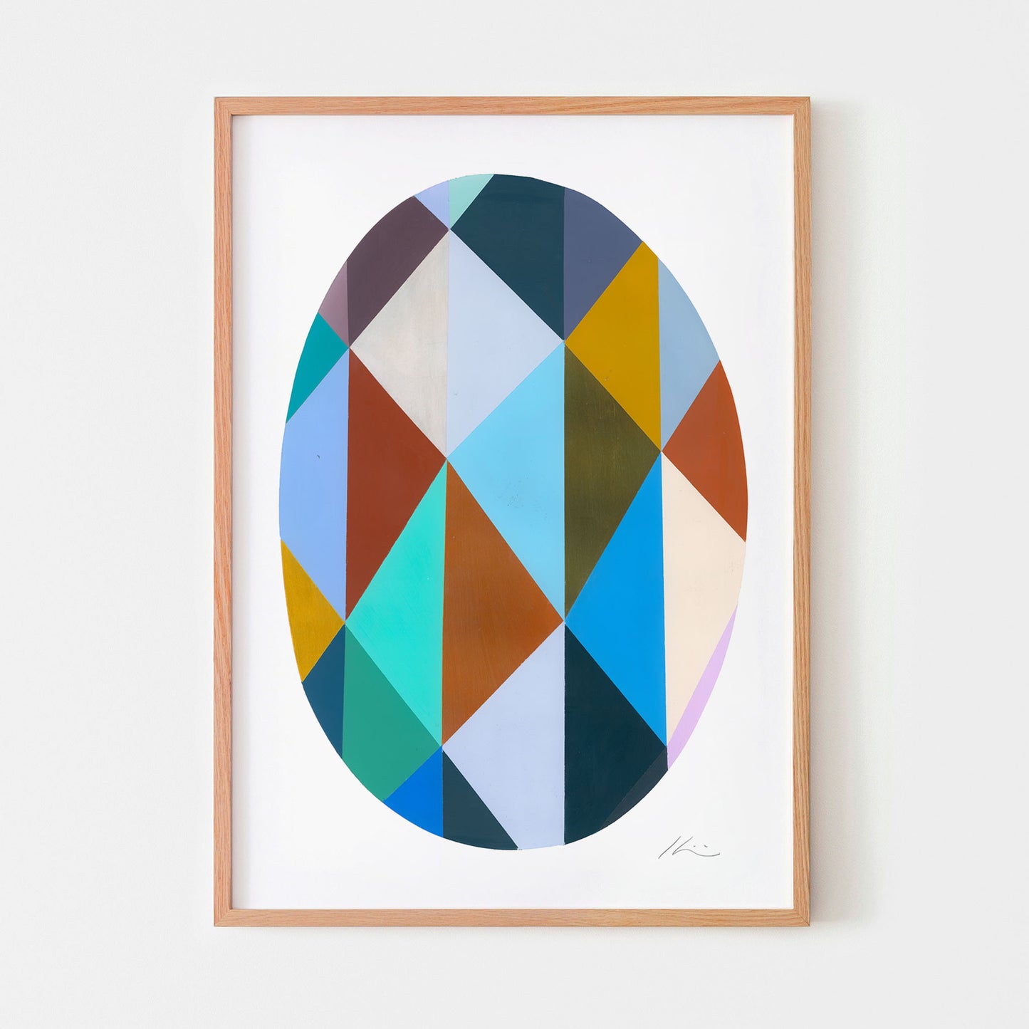 Framed abstract art print with geometric design on a white wall.