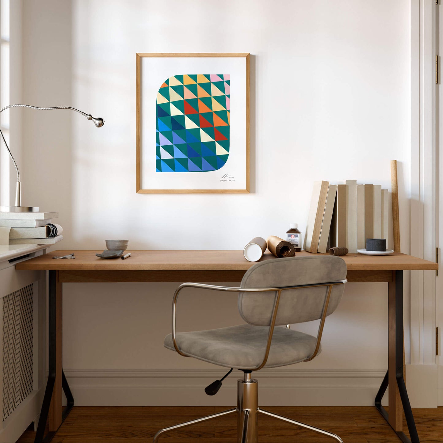 Geometric wall art above a desk in a home office space.