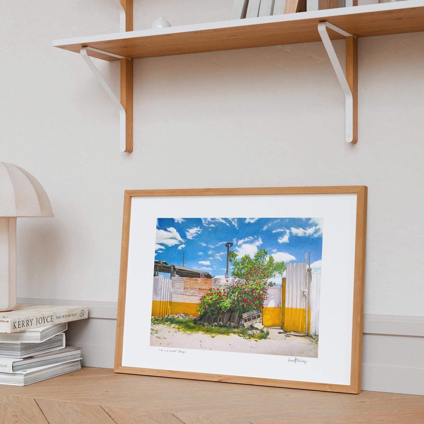 Modern landscape art print framed and leaning against a minimalist wall.