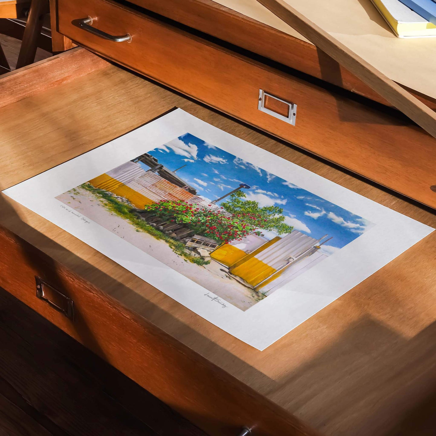 Unframed modern landscape art print in a draw in a studio.