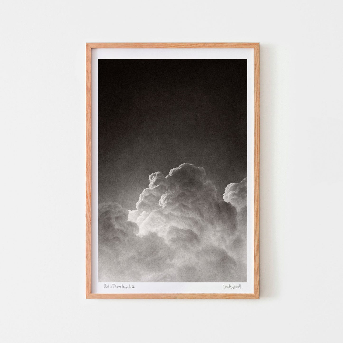 Small black and white wall art poster of a cloud in an oak frame.