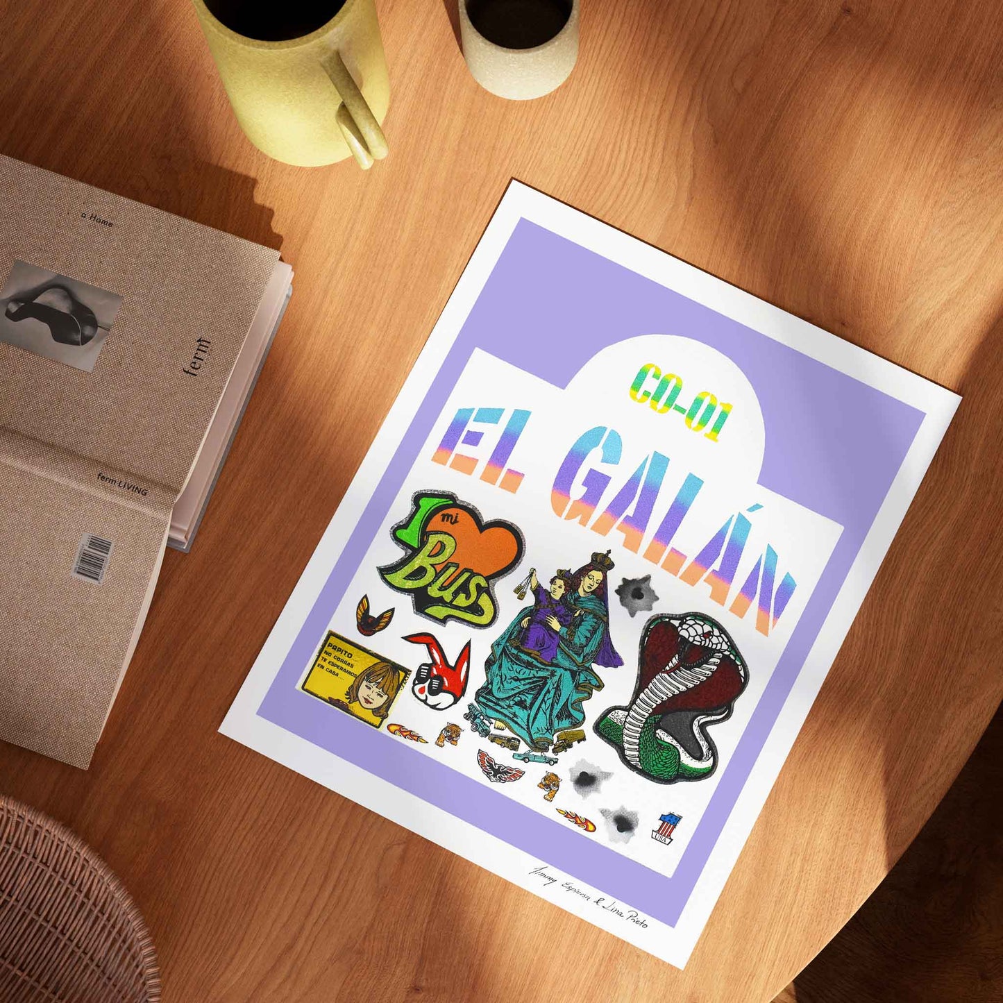 Colourful 'El Galán' art print on a wooden surface with a book and mug.