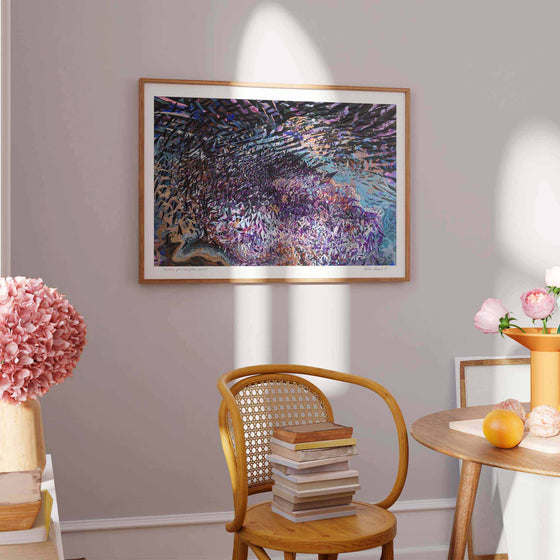 Large horizontal wall art print of a purple abstract landscape framed in a modern interior.