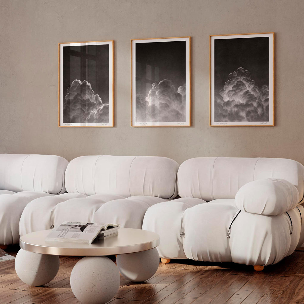 
                  
                    Set of three black and white wall art prints of clouds in a modern living room.
                  
                