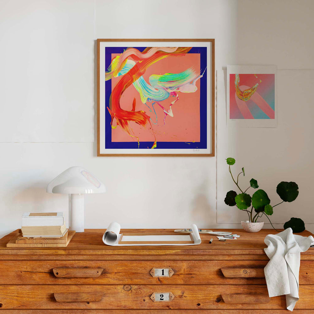 
                  
                    Bright contemporary art prints in a neutral interior with a wooden plan chest.
                  
                