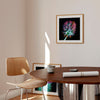 Square botanical wall art print in a neutral contemporary interior with a wooden table and chair.