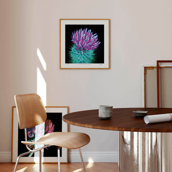 Purple and green thistle wall art print in a living space.