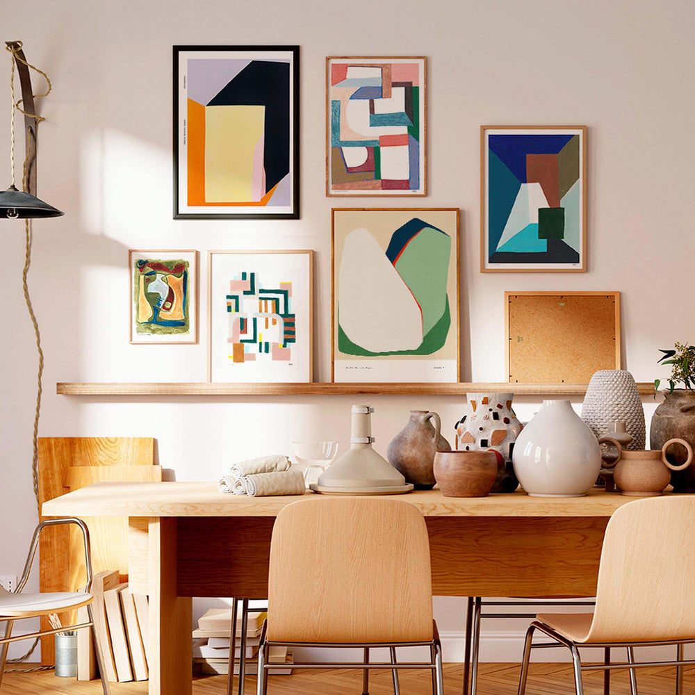 
                  
                    Gallery wall of abstract art prints in a neutral dining room and living space.
                  
                