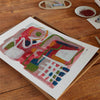 Abstract red art poster unframed on a wooden tabletop.