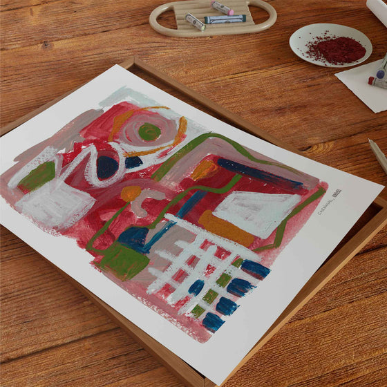 Abstract red art poster unframed on a wooden tabletop.