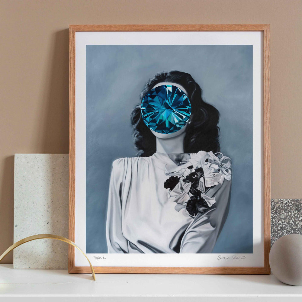 
                  
                    Modern portrait of a lady with a blue gem covering her face framed in a neutral interior space.
                  
                