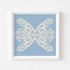 Square blue and white paper cut art print framed in white.